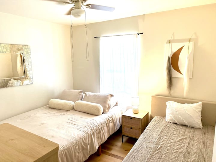 Dormitorio de invitados con cama tamaño queen y dos camas individuales 