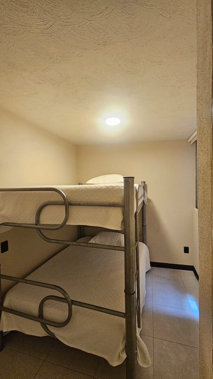 בחדר השינה השני יש מיטת קומותיים עם שתי מזרנים בגודל קווין סייז למנוחה שלכם.