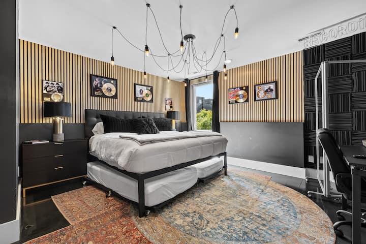 Music-inspired bedroom with gold records, unique lighting, and modern design—perfect blend of comfort and creative flair.