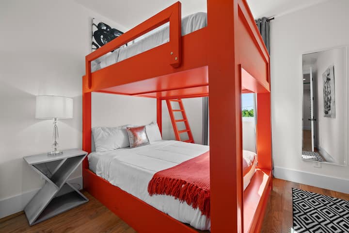 Fun and modern bunk room with bold orange frame and cozy bedding—perfect for groups or families looking for extra space and style.