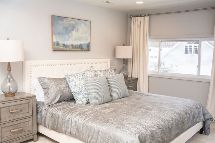 This spacious bedroom offers serene lake views, a comfortable king bed, and a sleeper sofa for extra guests. It shares a large bathroom with Bedroom 4, complete with a shower and bidet for added convenience and comfort.