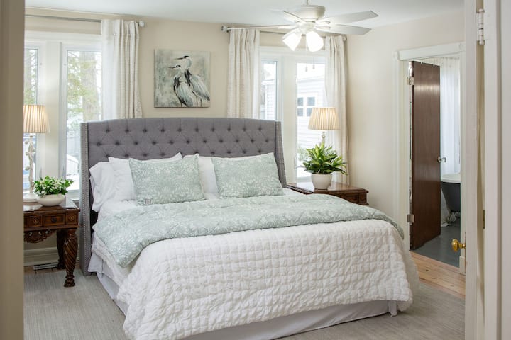 Spacious main-floor suite with a king bed, private ensuite featuring a walk-in shower and classic clawfoot tub. Includes a large walk-in closet and plenty of natural light for a restful retreat.