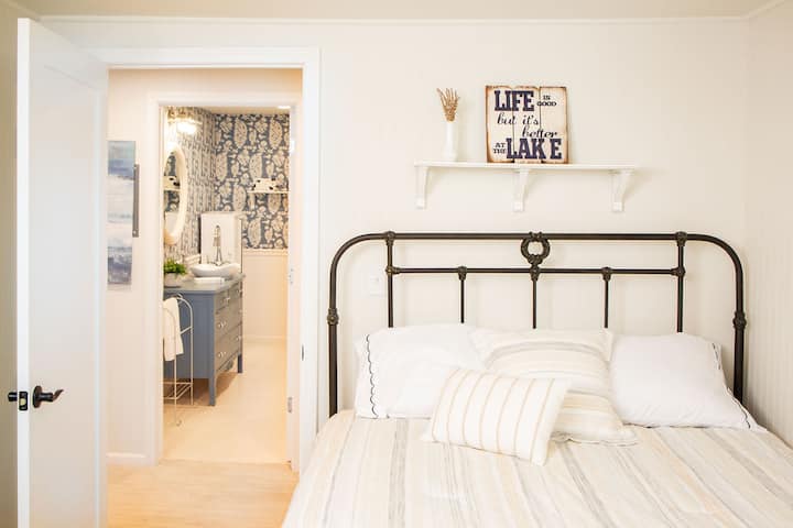 This inviting bedroom features a queen bed, closet, and dresser, along with beautiful lake views. It shares a bathroom with Bedroom 6 for added convenience.