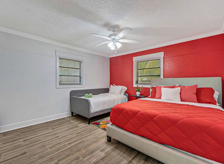 Bold reds & cozy layers — Stretch out or snuggle in with dual beds and vibrant tones in this guest-ready retreat