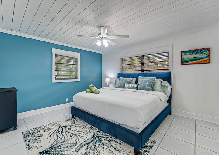 Blue walls & botanical calm — Drift into coastal comfort with layered pillows and breezy textures in this serene bedroom retreat