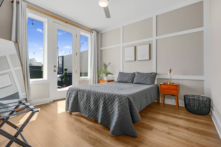 Wake up to rooftop views in this cozy, sunlit bedroom with direct patio access and soft, modern touches throughout.