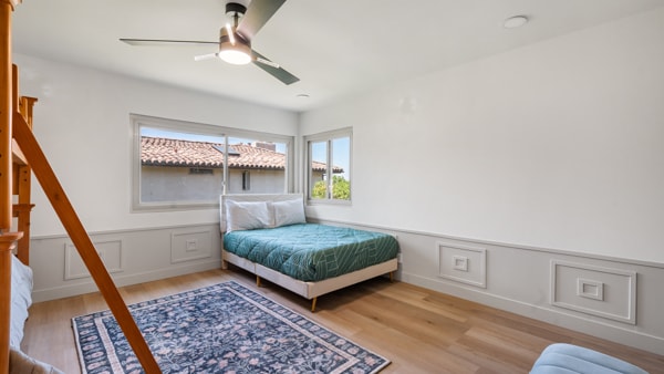 Cama tamaño queen con una litera con dos camas individuales en el dormitorio. 