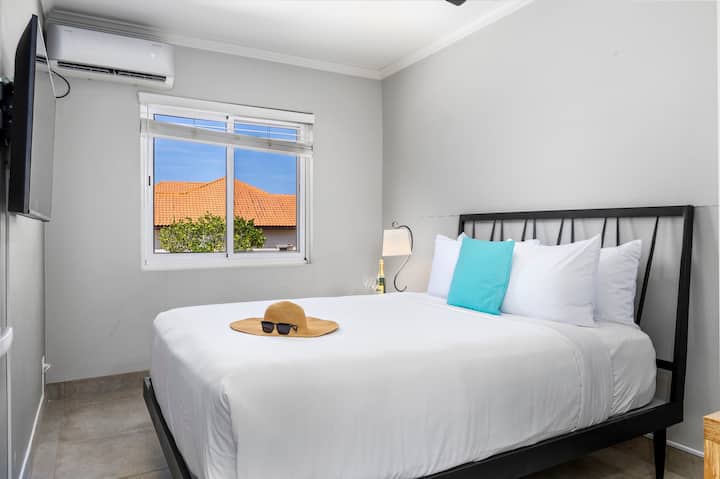 พักผ่อนอย่างสบายใจบนเตียงควีนไซส์ที่อบอุ่นพร้อมเครื่องปรับอากาศเย็นสบาย รายการโปรดของคุณบนทีวี และที่เก็บเสื้อผ้ามากมายเพื่อให้คุณรู้สึกเหมือนอยู่บ้าน