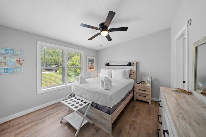 Ნათელი საძინებელი ორადგილიანი საწოლით, კომოდითა და დიდი ფანჯრებით, რომლებიც ეზოს გადაჰყურებს. Მოიცავს ჭერის ვენტილატორს და ბევრ ბუნებრივ განათებას.