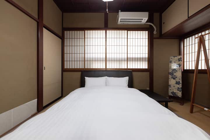 ダブルベッド1台の畳のお部屋。隣のお部屋とは襖で区切られています。