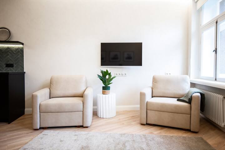 - Ambient ndenjjeje modern dhe i ndriçuar me kolltukë të rehatshëm për t'u çlodhur
- Dekor minimalist elegant, i përsosur për vizitorët e Airbnb
- Hapësirë e rehatshme jetese me televizor inteligjent që përmirëson qëndrimin tënd në apartament me rehati të përditshme