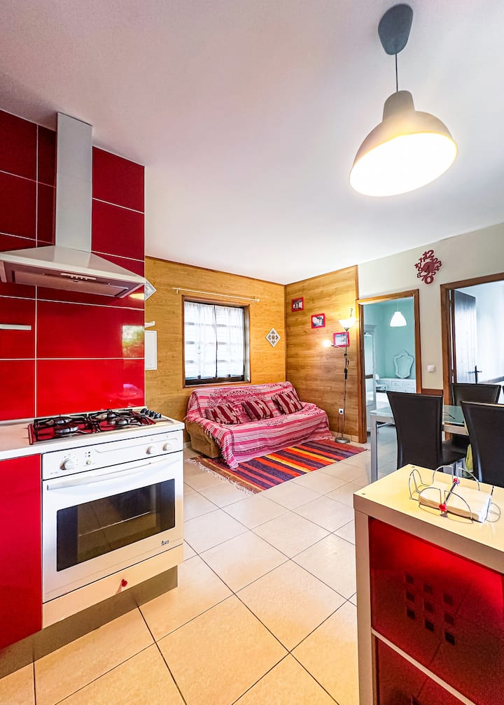 Cocina y salón, con fogones, horno, salamandra, encimera, mesa de comedor de cristal con 4 cómodas sillas, sofá, TV, microondas, cafetera, tetera, varias luces distribuidas, vajilla ¡todo equipado! 