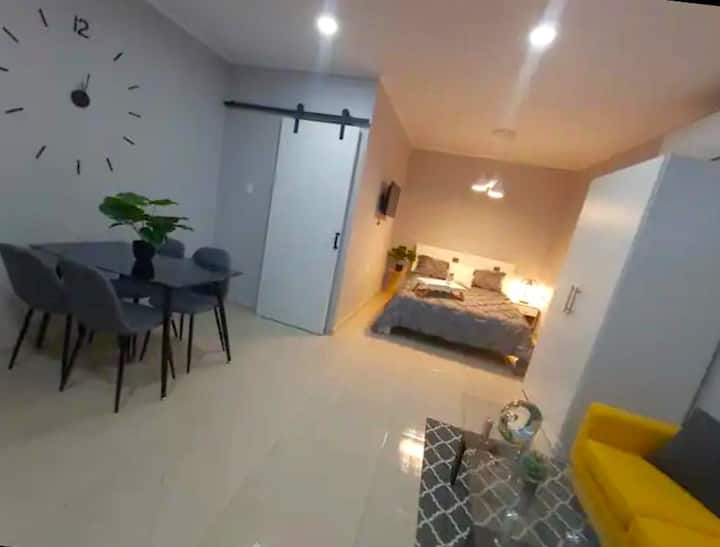 Дневна и спална област со отворен план со удобен брачен кревет (широк 150 – 179 см), стилски кауч и светол модерен декор – совршен спој на удобност и стил.
