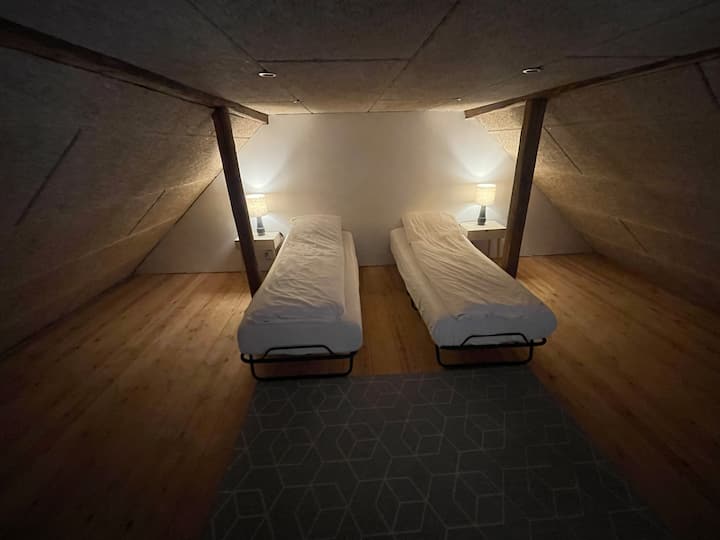 Roshani yenye vitanda viwili vya mtu mmoja ambavyo vinaweza kusukumwa pamoja kwa urahisi ikiwa vinataka.
Vitanda ni sentimita 80x197