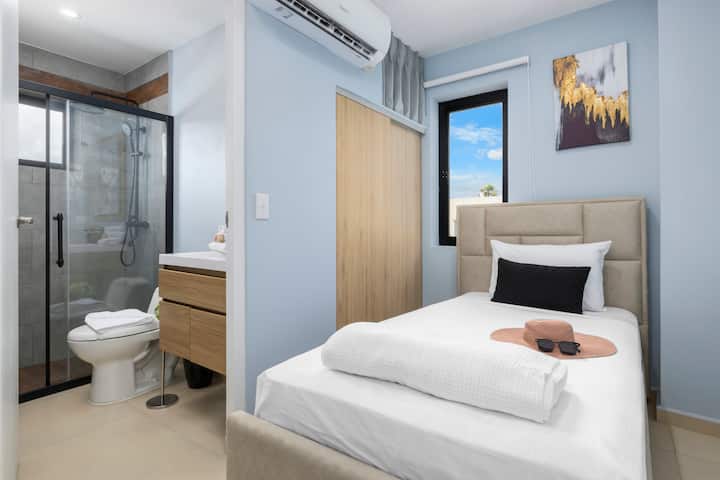 Განიტვირთეთ ამ ნათელ და მყუდრო საძინებელში, რომელშიც დგას ორადგილიანი საწოლი, ხრაშუნა თეთრეული და თანამედროვე თავსაფარი, რომელიც აღჭურვილია სააბაზანოთი, გამაგრილებელი კონდიციონერით, გემოვნებიანი კედლის ხელოვნებითა და დიდი ფანჯრიდან ბუნებრივი სინათლით