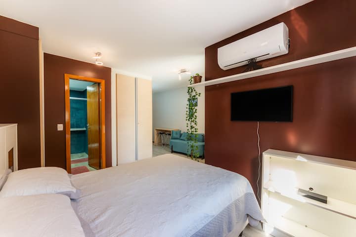 Стените в луксозно кафяво създават уютна атмосфера.
Таблата на леглото с осветени ниши, място за съхранение.
Прозорецът с жалузи позволява навлизането на естествена светлина.
Vineyard Plants добавя нотка на природа към околната среда.