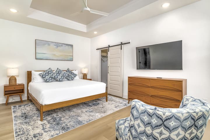 Relax in the soothing master bedroom, featuring a king size bed, a 58" smart tv and an ensuite bathroom with a walk-in shower.