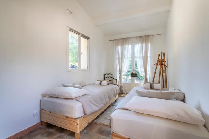 Светла спалня с 2 легла с ширина 80 см.  Пресечете перголата и ще имате достъп до спалня 1, кухнята и банята/тоалетната.