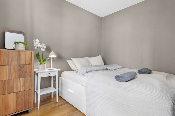 ห้องนอนสะอาดและอบอุ่นพร้อมเครื่องนอนนุ่ม สีโทนธรรมชาติ และสัมผัสที่พิถีพิถัน ไฟข้างเตียงและการตกแต่งที่เรียบง่ายช่วยสร้างพื้นที่ที่เงียบสงบและสะดวกสบาย เหมาะสำหรับการพักผ่อนหลังจากออกไปเที่ยวมาทั้งวัน
