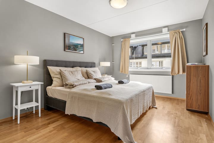 ห้องนอนที่สะดวกสบายพร้อมเตียงขนาดใหญ่ ผ้าปูที่นอนนุ่ม และโทนสีธรรมชาติที่ให้ความรู้สึกอบอุ่น แสงธรรมชาติส่องเข้ามาในที่พักผ่านหน้าต่างบานกว้าง สร้างบรรยากาศที่เงียบสงบเหมาะสำหรับการพักผ่อนยามค่ำคืนและการเข้าพักที่ผ่อนคลาย
