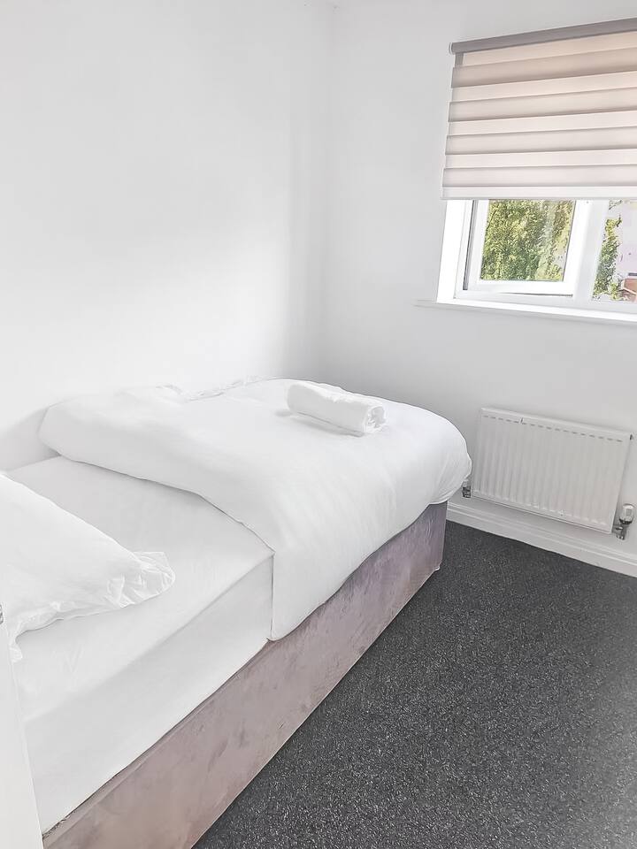 El dormitorio 3 ofrece un espacio acogedor y cómodo con una cama individual, perfecta para un niño, un invitado o una oficina en casa. Su diseño limpio y minimalista crea un ambiente tranquilo y práctico para descansar o trabajar.