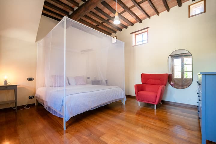La casa de huéspedes privada conectada a la casa principal tiene una cama tamaño king con mosquitero y marco, un pequeño sofá de dos plazas, una silla, un tocador, mesitas de noche, cocina, mesa de comedor, vestidor con armario y baño privado con ducha.