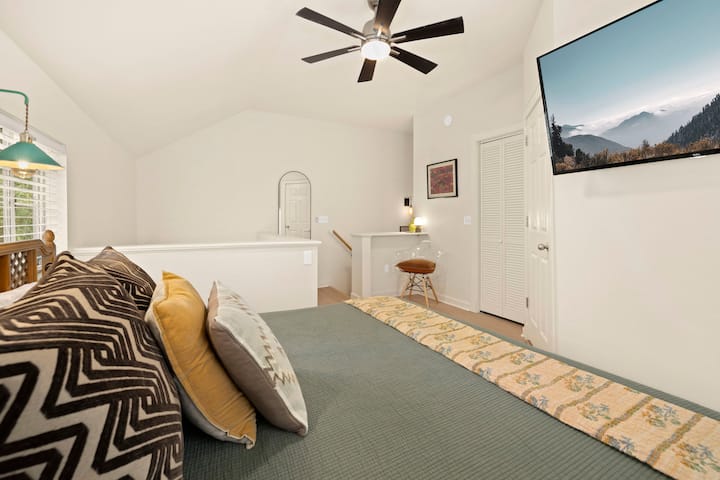 Llegas arriba a este dormitorio de estilo loft totalmente espacioso con techos abovedados, ropa de cama acogedora y un televisor inteligente para relajarte.