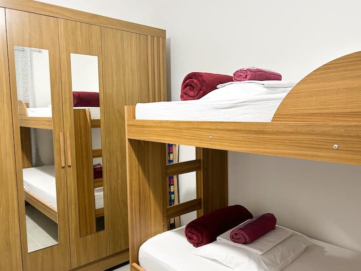 Habitación con aire acondicionado, cómodas camas, una litera y una cama nido, armario y cortina opaca