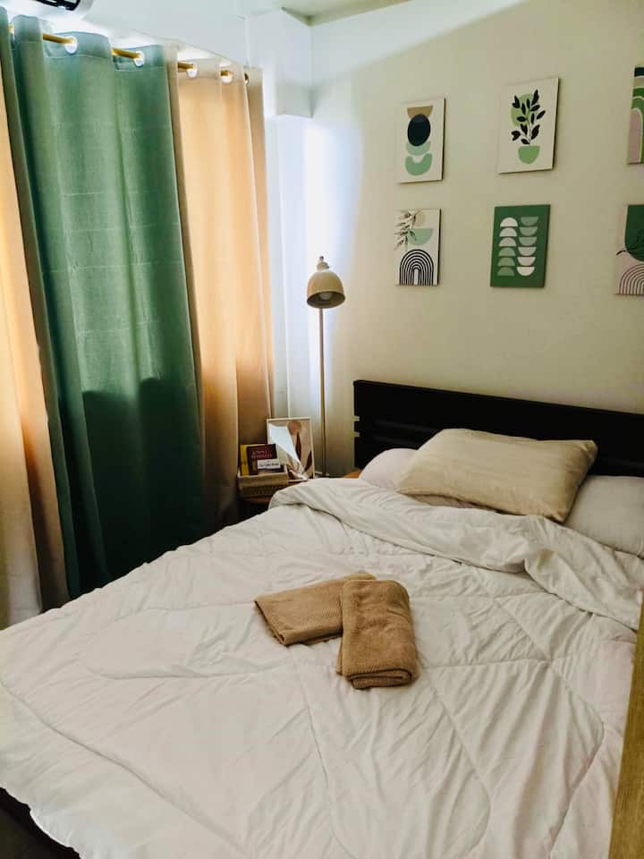 Მყუდრო ოთახი დედოფლის ზომის საწოლით, ნახევრად უშუქო ფარდებითა და გამძლე ლამპით - იდეალურია მშვიდი ღამეებისა და მშვიდი დილისთვის.