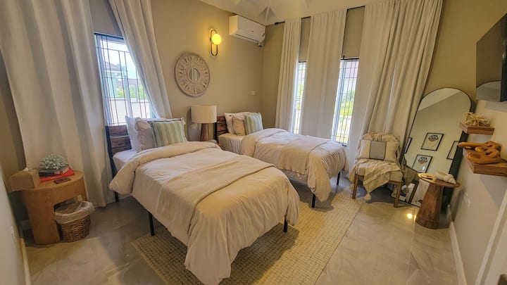 Стилска трета спална соба со удобна удобност и крајбрежни акценти во Villa on the Rocks.