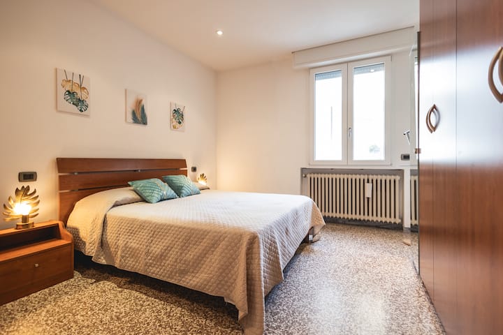 Chumba kikubwa cha kulala chenye meza 2 za kando ya kitanda, kabati la nguo, kabati la droo na rafu ya viatu.