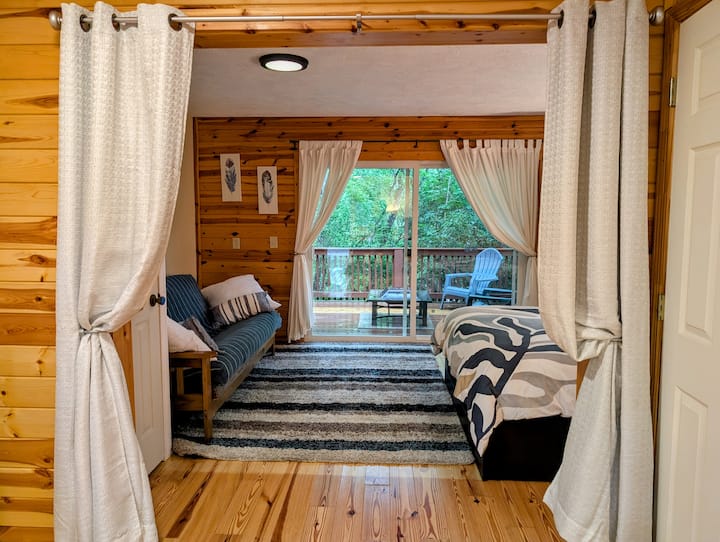 Спалня в къщата за гости на приземния етаж, отделена със завеса от стаята за игри