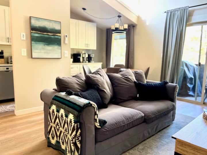 Klenuté stropy, prirodzené svetlo a útulný krb robia z tejto obývacej izby srdce Snuggly Otter – ideálne miesto na rodinné herné večery alebo pokojné rána.