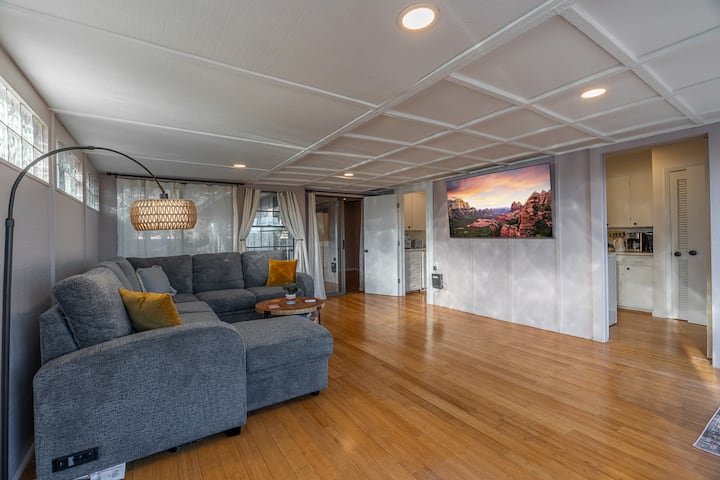 宽敞迷人的起居区，配有豪华组合沙发、智能电视和温暖的木地板，非常适合电影之夜、与家人放松或在一天的探险后放松身心。