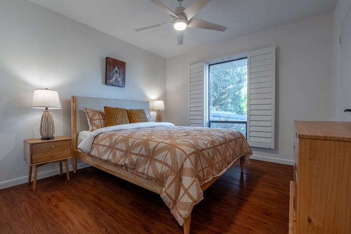 舒适迷人的卧室，配有舒适的床、温暖的木地板和柔和的灯光。 带百叶窗的大窗户提供自然光，营造出一个宁静的空间，让您安然入睡。