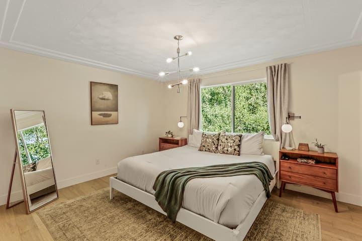 Amplio dormitorio principal con vistas al bosque y una lujosa cama tamaño king. Ideal para parejas o para un retiro en solitario en este tranquilo alquiler vacacional familiar en Spokane