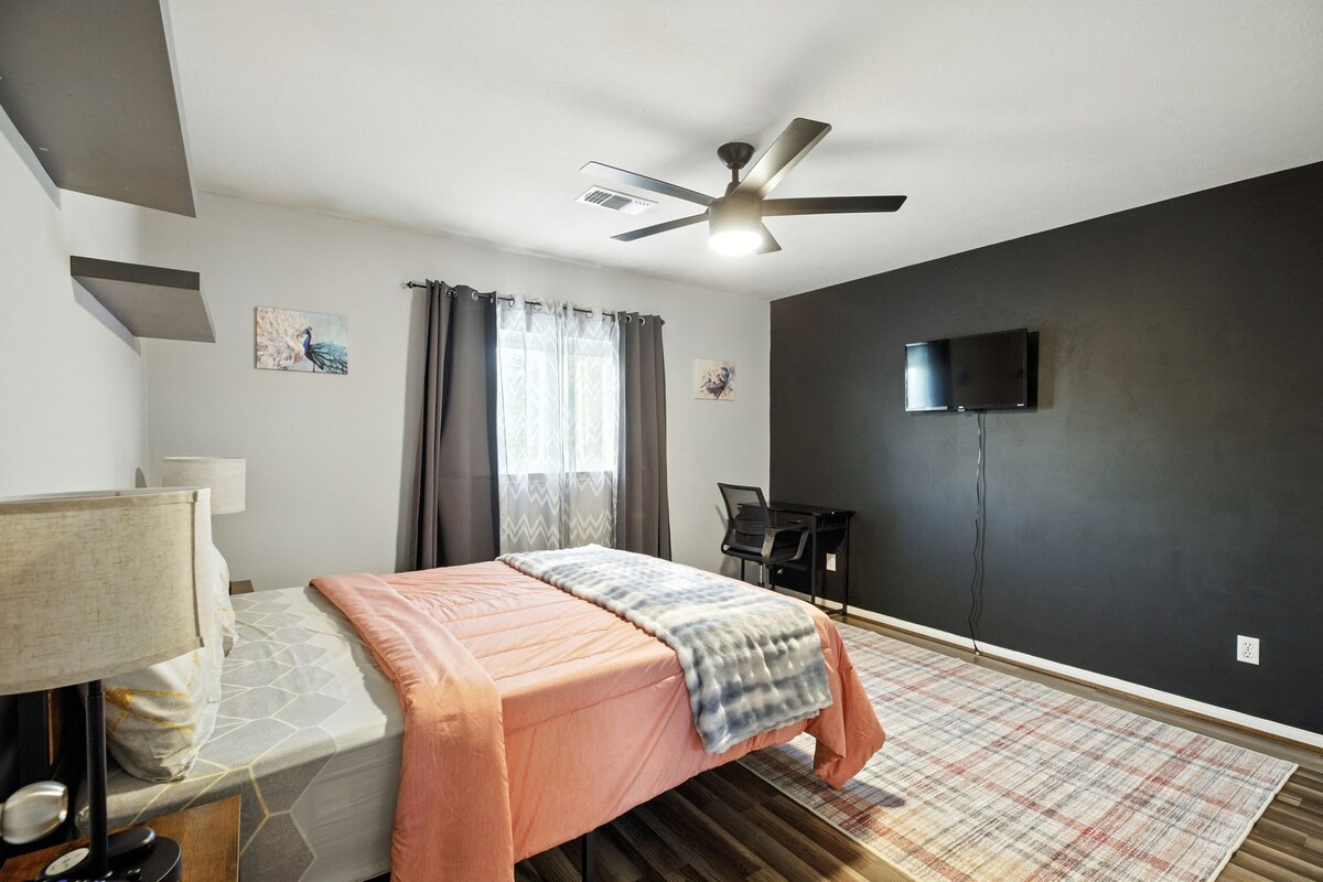 חדר שינה בסגנון קווין סייז עם טלוויזיה, שולחן עבודה, ארון וקיר מודרני עם גוון שחור