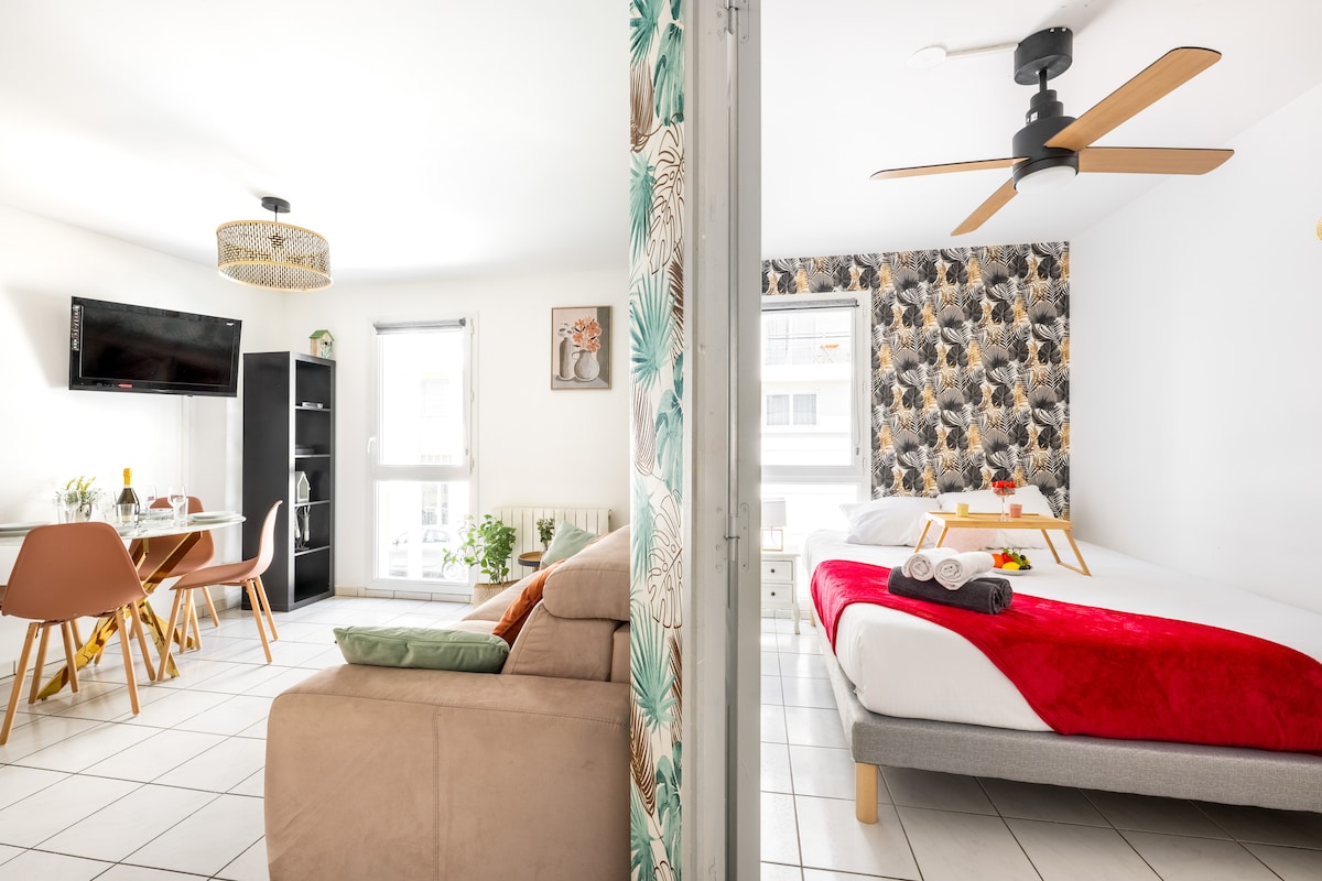 تُظهر هذه الصورة غرفة المعيشة مع سرير أريكة مزدوج وطاولة تتسع لأربعة أشخاص وتلفزيون وغرفة نوم منفصلة مع سرير مزدوج.