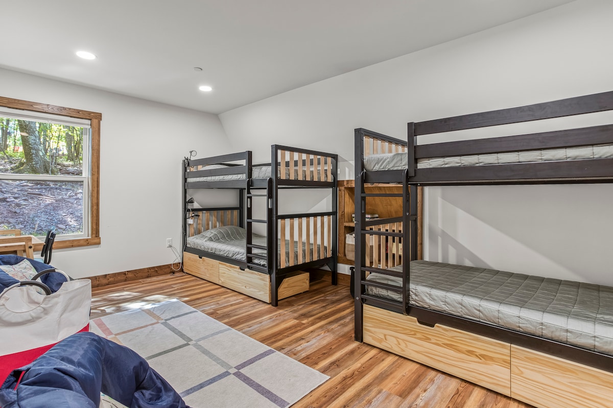 Двуетажни легла, чекмедже за съхранение под леглото, индивидуални лампи за четене, пуфове, бюро и кошници с играчки. Тази стая е създадена за децата!