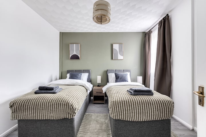 现代化卧室，配备两张单人床和室内电视娱乐设施