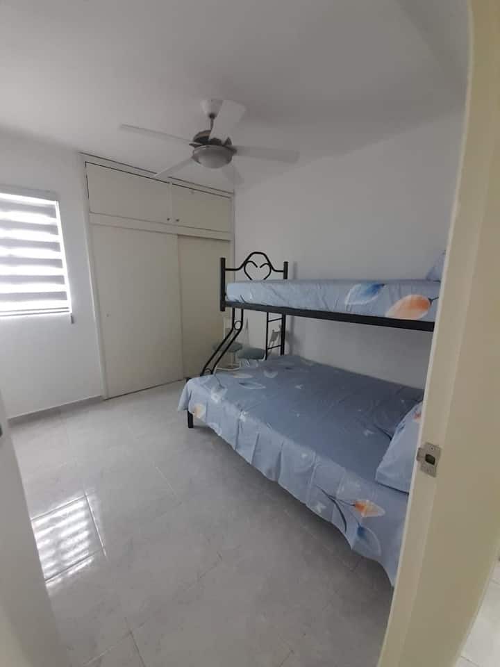 Quarto aconchegante com dois beliches, com capacidade para 3 pessoas. Perfeito para um grupo de amigos ou familiares. Inclui um armário, ventilador de teto e ar condicionado para maior conforto.