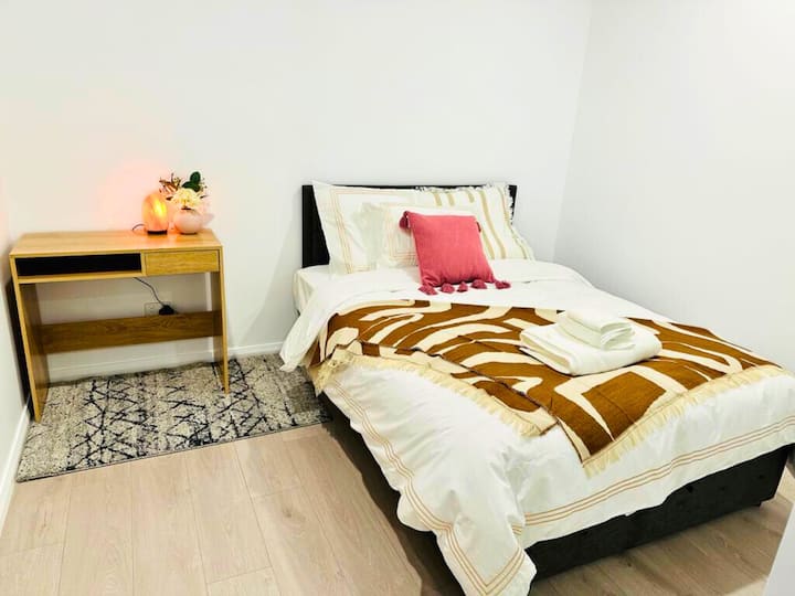 Удобна спална соба со удобна канцелариска маса со ламба за читање и солена ламба, пенкала, белешки и удобен стол