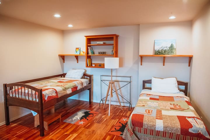 Deux lits simples dans la chambre du bas. La chambre à coucher dispose également d'un lit queen size. Jouets et livres pour enfants. 