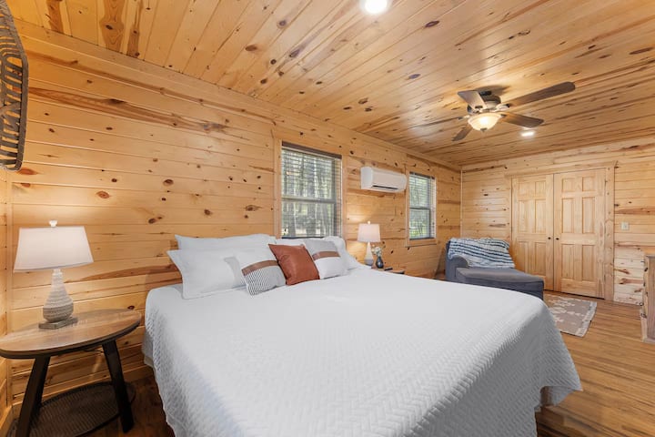 מיטת קינג סייז מפוארת מזמינה אתכם להירגע, בעוד שהמבטא של העץ החם של הבקתה יוצר את מקום הנופש המושלם!