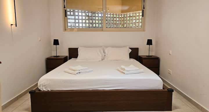 توفر غرفة النوم الثانية سريرًا مريحًا بحجم كينج، ومصابيح بجانب السرير للقراءة في وقت متأخر من الليل، ومرآة عملية، مما يجعلها أنيقة وعملية لإقامتك.