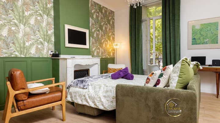 La paleta tropical y acogedora invita a la relajación: un sofá verde mullido, un sillón vintage y toques de violeta. Espacio de oficina soleado para escribir sus recuerdos después de un día bajo la brisa occitana.