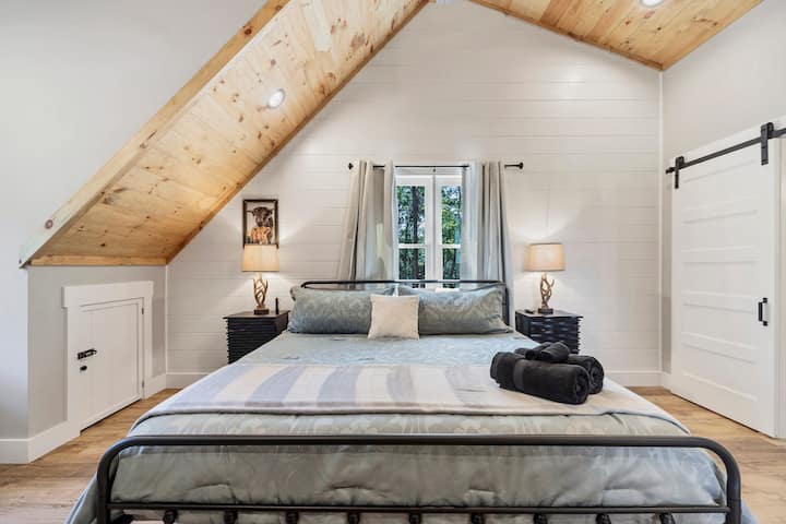 Spálňa na poschodí má posteľ veľkosti king, komodu, nočné stolíky s USB zásuvkami, skriňu s vešiakmi, stojan na batožinu a vysoké klenuté stropy, ktoré vytvárajú otvorenú a vzdušnú atmosféru.