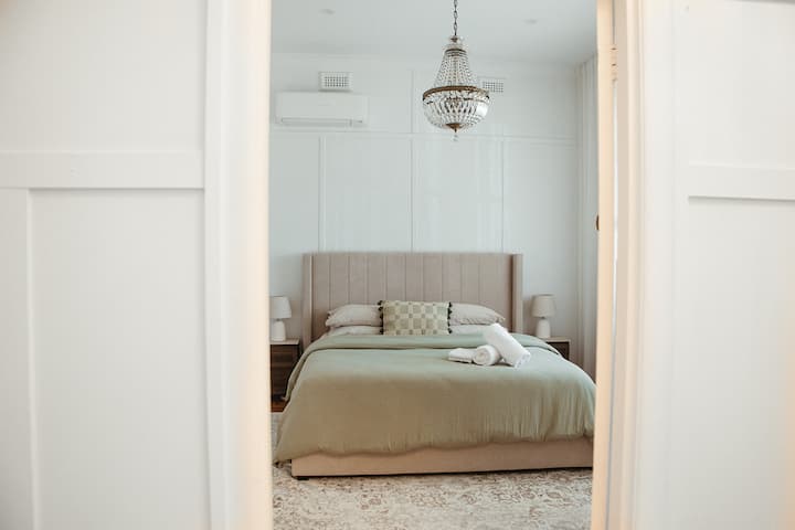 Una habitación de tamaño generoso con una lujosa cama tamaño king, bañada de luz natural que destaca el ambiente cálido y acogedor. Diseñado para la comodidad y la privacidad, ofrece un refugio tranquilo para relajarte y descansar.