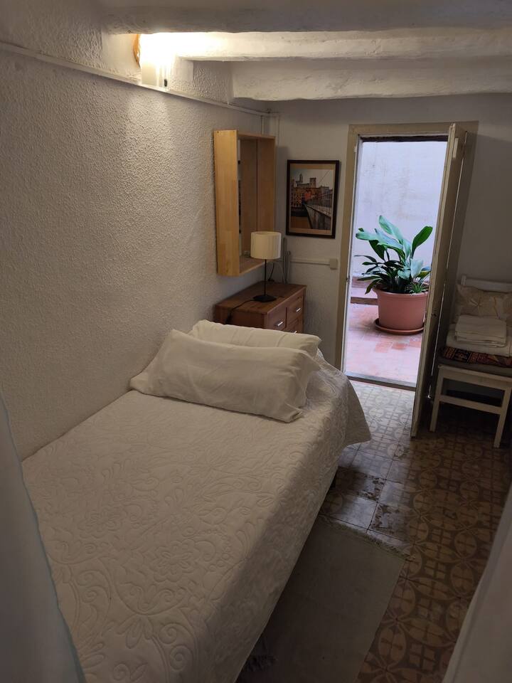 Habitación individual seguido del salón en primer piso. Con acceso a un patio interior y al lado del baño