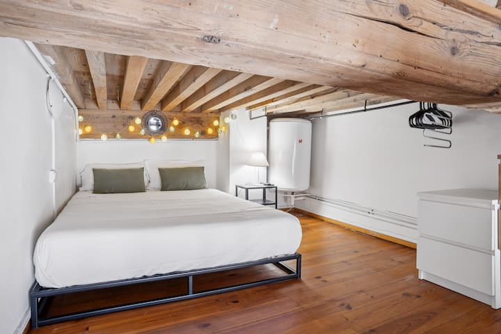 Dhomë e bukur në tarracë, trarë druri dhe dekorim i pastër për një atmosferë qetësuese.